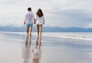 Coppia in spiaggia italiana passeggiano durante vacanza low cost estate 2026