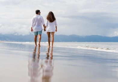 Coppia in spiaggia italiana passeggiano durante vacanza low cost estate 2026